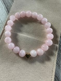 "Made with 8mm round Madagascar Rose Quartz beads on stretch cord and a gold played heart shaped accent bead.  Size-7 inches. If you need a larger bracelet please leave a note in the checkout letting me know the length desired. I am happy to customize the size at no additional charge. (I.E. Hi! Can you make this bracelet for me 8 inches long.)  When I choose stones I seek them based on what speaks to my heart. It is my hope that those who need this stone, will find it.   Here are some notes Rose Quartz:     * Properties: Known as the \"Stone of Love,\" rose quartz is associated with love, compassion, and emotional healing.     * Usage: Ideal for promoting self-love, attracting love into one's life, and fostering harmonious relationships." Valentine's Day Heart Beads Stretch Bracelet, Valentine's Day Heart-shaped Stretch Bracelet With Heart Beads, Heart-shaped Stretch Bracelet With 8mm Beads As Gift, Pink Heart-shaped Spiritual Beaded Bracelets, Pink Stretch Bracelet With Heart Charm For Valentine's Day, Pink Heart Charm Stretch Bracelet For Valentine's Day, Valentine's Day Gift Stretch Bracelet With 8mm Beads, Valentine's Day Stretch Bracelet With Heart Charm, Valentine's Day Heart Charm Stretch Bracelet