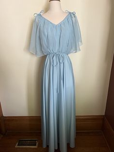 "Vintage handmade 70s Greek style maxi dress.  Beautiful pale blue 70s maxi dress, sleeveless body with sheer butterfly sleeves with decorative ties on top of shoulder. Sheer bloused bodice with v-neckline in front and back. Sash at waist. Elasticized waist that hits slightly below bust line, full, floor length skirt. Back zip with hook and eye closure. I have listed this as handmade because I could find no evidence of any tags. No material listed, but feels synthetic, and material does have str Summer Evening Maxi Dress With Butterfly Sleeves, Vintage Blue Maxi Dress For Formal Occasions, Blue Vintage Chiffon Dress, Butterfly Sleeve Maxi Dress For Spring Evenings, Spring Evening Maxi Dress With Butterfly Sleeves, Maxi Dress Sleeveless, 70s Maxi Dress, Sheer Overlay, Oak Park