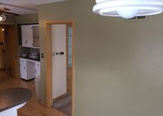 an empty kitchen and living room in a house with wood flooring on the walls