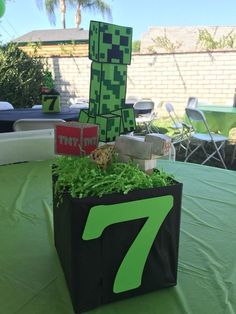 a table topped with a black bag filled with green plants and an 8 - 7 figure