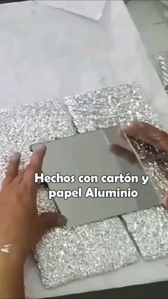 two hands are working on some silver glittered paper with the words hechos con carton y papel alumino