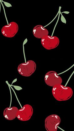 cherries on a black background with green stems