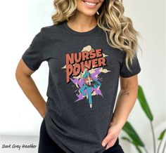 a woman with her hands on her hips wearing a t - shirt that says nurse power