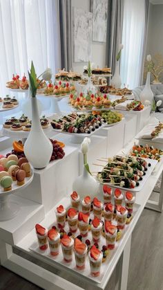 an assortment of desserts are displayed on a long table