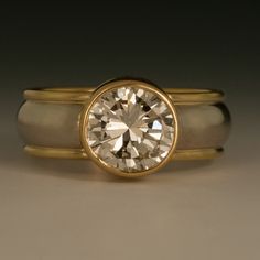 a close up of a ring with a diamond in the center and two bands around it