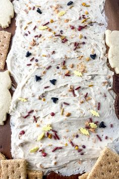 a cake with white frosting and sprinkles next to crackers