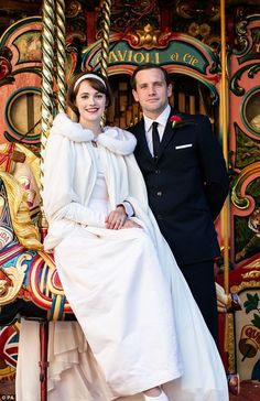 a man and woman standing next to each other on a merry go round