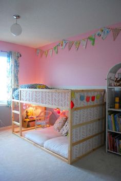 a child's bedroom with bunk beds and pink walls