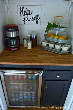 an appliance is displayed on the wall next to a refrigerator and coffee maker