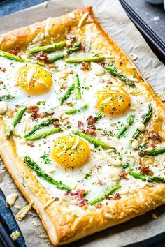 a square pizza with asparagus and eggs on it