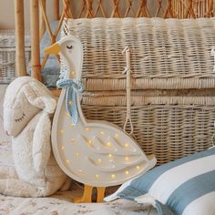 a stuffed animal sitting on top of a bed next to a pillow and basket filled with pillows