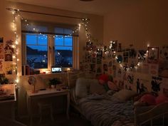 a bedroom with lights strung from the ceiling and pictures on the wall above the bed