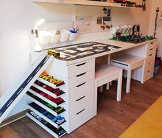 a white desk with drawers and shelves filled with various items on it's sides