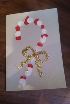 a white card with gold and red decorations on it, sitting on a wooden table