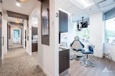 a dental office with chairs and desks in the hallway next to windows that look out onto another room