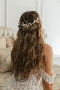 a woman with long hair wearing a white dress and a flower headpiece in her hair