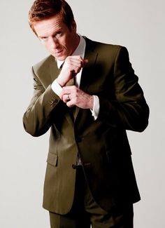 a man in a suit adjusting his tie