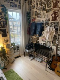 a living room with guitars and pictures all over the wall, including a guitar sitting in front of a window