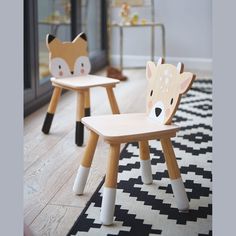 two children's wooden chairs sitting on top of a black and white rug