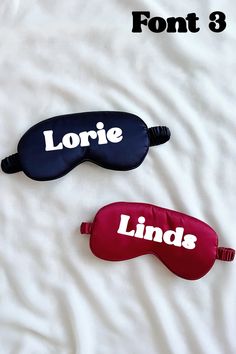 two personalized sleep masks laying on top of a white sheet with the words lorie and linds