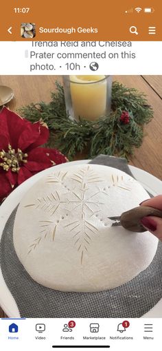 someone using a knife to cut out a snowflake design on a cake plate