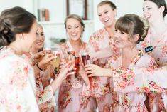 a group of women standing next to each other holding wine glasses