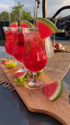 three glasses filled with watermelon and limeade sitting on top of a cutting board