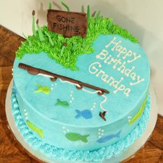 a blue birthday cake with an image of a fishing rod and fish on the top