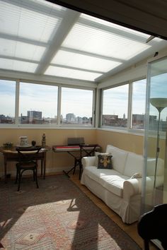 a living room filled with furniture and large windows