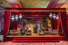 a stage set up with red drapes and chandeliers