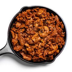 a skillet filled with meat sitting on top of a white table