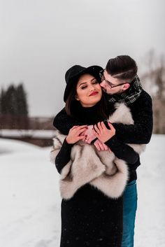 a man and woman hugging in the snow