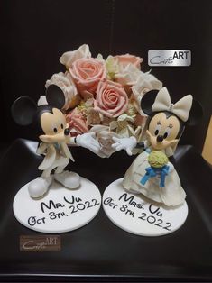 mickey and minnie mouse wedding cake toppers on display at the disney world art show