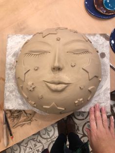 a person is making a face out of clay