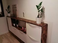 a plant is sitting on top of a shelf in a room with white walls and wood floors