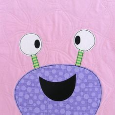 a close up of a pink and purple wall hanging with an animal face on it