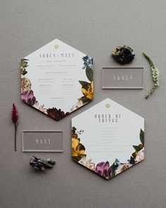 the wedding stationery is laid out on top of each other, with flowers and greenery