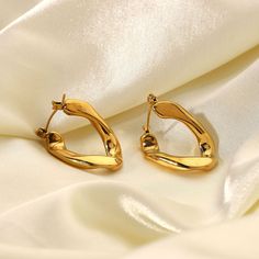 These lovely Caroline Earrings have a wavy style that can be worn on any occasion. Made from 100% stainless steel & dipped in 18K gold, this jewelry piece is simple enough to accessorize easily but creative enough to make your look stand out. Details: 18k Gold Plated Stainless Steel Minimalist Plated Metal Hoop Earrings, Trendy Yellow Gold Stainless Steel Earrings, Trendy Yellow Gold Metal Earrings, Pierced Yellow Gold Stainless Steel Earrings, Yellow Gold Plated Stainless Steel Earrings, Yellow Gold Stainless Steel Drop Earrings, Modern Plated Hoop Earrings For Gift, Gold-tone Stainless Steel Earrings, Trendy Matte Gold Metal Earrings