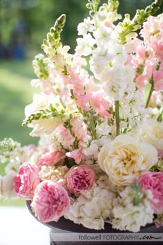 a vase filled with lots of pink and white flowers