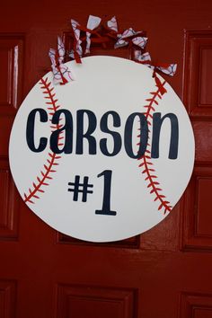 a baseball door hanger with the number 1 on it, and ribbon tied to it