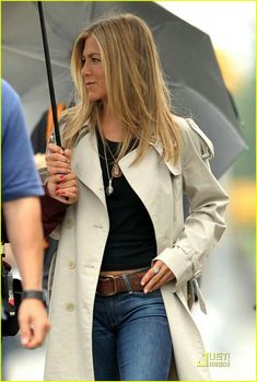 a woman holding an umbrella while walking down the street