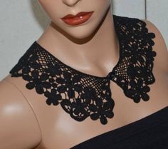 a mannequin wearing a black top with lace on it's neckline