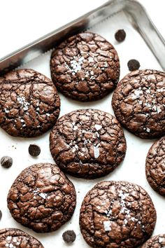 chocolate cookies on a baking sheet covered in powdered sugar