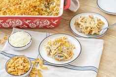 several plates of food on a table with bowls and spoons next to the casserole