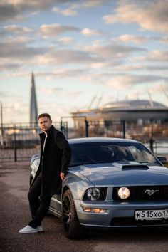 a man leaning on the hood of a car