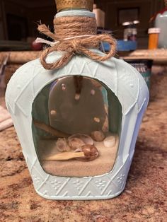 a bottle with sand inside sitting on top of a table