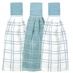 three towels are lined up in different colors and patterns, one is blue and the other is white