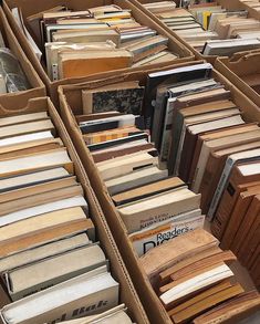 many different types of books are stacked on top of each other in bins outside