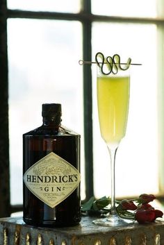 a bottle of hendirick's gin next to a glass filled with liquid