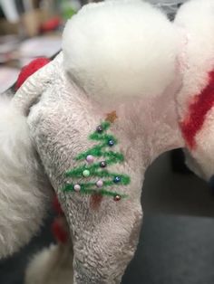 a white stuffed animal with a christmas tree on it's back